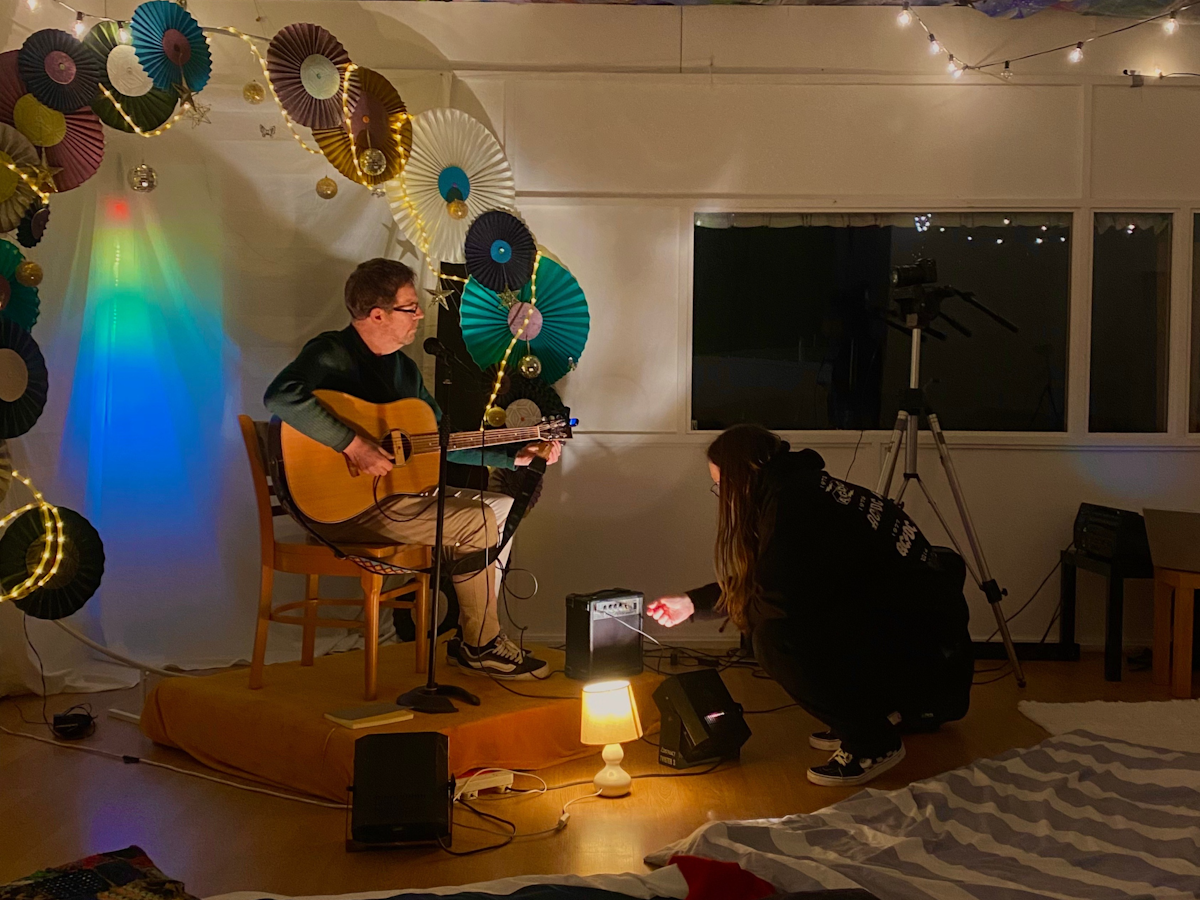 A volunteer adjusts sound levels while an artist performs
